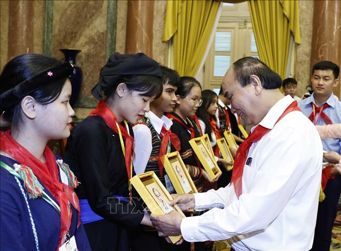 President Nguyen Xuan Phuc presents the portrait of Uncle Ho to the children. VNA Photo: Thống Nhất