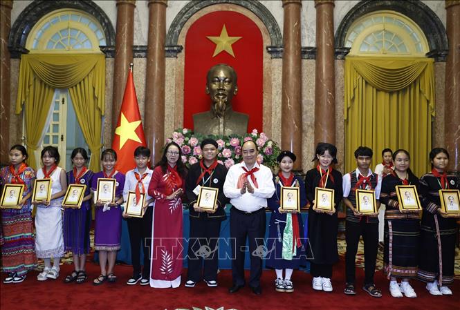 President Nguyen Xuan Phuc presents the portrait of Uncle Ho to the children. VNA Photo: Thống Nhất