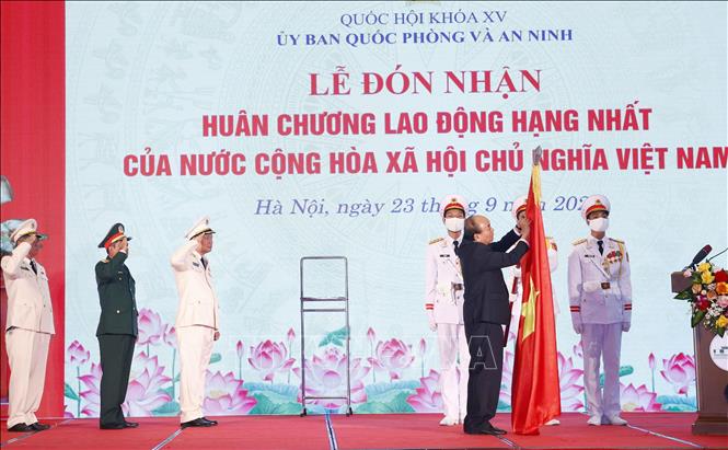  Chủ tịch nước Nguyễn Xuân Phúc gắn Huân chương Lao động hạng Nhất lên cờ truyền thống của Uỷ ban Quốc phòng và An ninh của Quốc hội. Ảnh: Doãn Tấn - TTXVN
