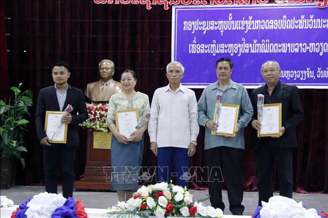 Trưởng Ban Tuyên giáo Trung ương Đảng Nhân dân cách mạng Lào Khamphan Pheuyavong (giữa) với các tác giả được giải nhì tại cuộc thi. Ảnh: Phạm Kiên - Pv TTXVN tại Lào