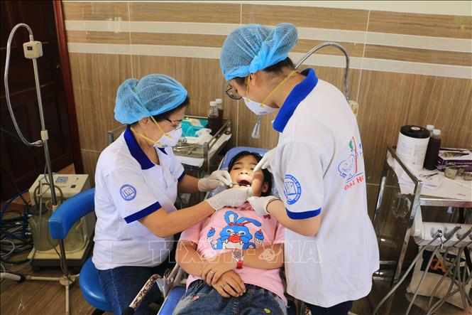 Lực lượng y tế khám răng, hàm, mặt cho trẻ em. Ảnh: Phạm Minh Tuấn-TTXVN.