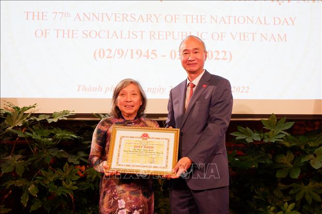Ambassador Phung The Long presents a certificate of merit from the State Committee for Overseas Vietnamese Affairs to the Vietnamese Association in Switzerland. VNA Photo: Xuân Hoàng