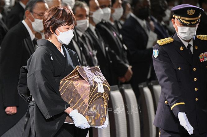Trong ảnh: Phu nhân Akie Abe (trái) mang tro cốt của cố Thủ tướng Nhật Bản Abe Shinzo vào hội trường Nippon Budokan (Tokyo), nơi diễn ra lễ quốc tang, ngày 27/9/2022. Ảnh: AFP/TTXVN