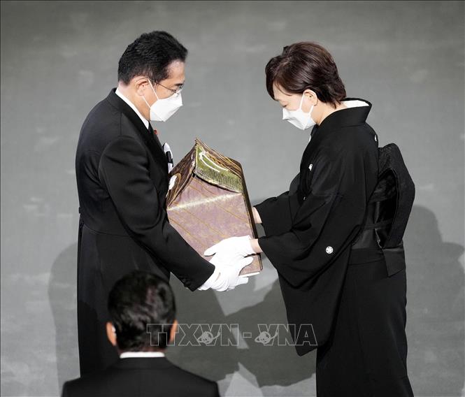 Trong ảnh: Phu nhân cố Thủ tướng Nhật Bản Abe Shinzo, bà Abe Akie (phải) trao hũ tro cốt của chồng cho Thủ tướng Kishida Fumio trong Lễ Quốc tang tại Tokyo ngày 27/9/2022. Ảnh: AFP/TTXVN
