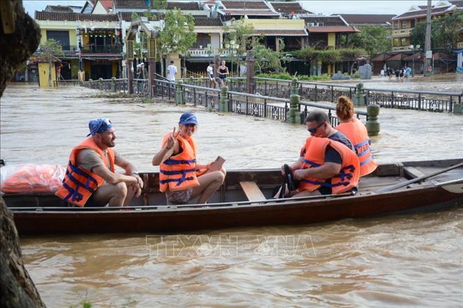 Khách du lịch vui thích khi trải nghiệm cảnh ngập lụt ở phố cổ Hội An. Ảnh: Văn Dũng - TTXVN