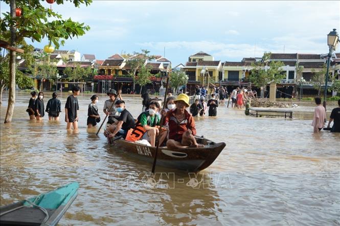 Khách du lịch vui thích khi trải nghiệm cảnh ngập lụt ở phố cổ Hội An. Ảnh: Văn Dũng - TTXVN