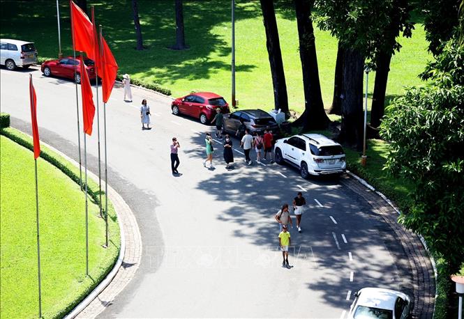 Trong ảnh: Du khách quốc tế dạo chơi trong khuôn viên xanh mát Dinh Thống Nhất. Ảnh: Hồng Đạt - TTXVN
