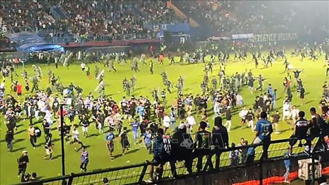 Trong ảnh: Cảnh hỗn loạn khi các cổ động viên tràn xuống sân Kanjuruhan trong trận đấu giữa Arema FC và Persebaya Surabaya ở tỉnh Đông Java, Indonesia tối 1/10/2022. Ảnh: hindustantimes.com/TTXVN