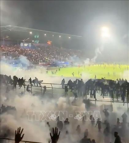 Trong ảnh: Cảnh hỗn loạn khi các cổ động viên tràn xuống sân Kanjuruhan trong trận đấu giữa Arema FC và Persebaya Surabaya ở Malang, tỉnh Đông Java, Indonesia tối 1/10/2022. Ảnh: Twitter/@akmalmarhali/TTXVN
