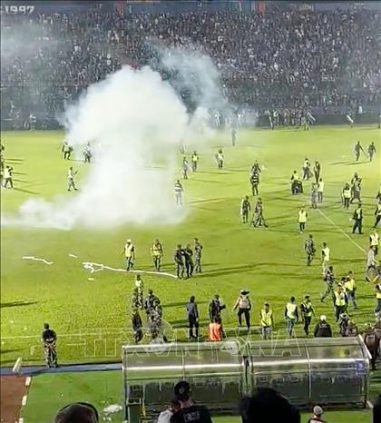 Trong ảnh: Cảnh hỗn loạn khi các cổ động viên tràn xuống sân Kanjuruhan trong trận đấu giữa Arema FC và Persebaya Surabaya ở Malang, tỉnh Đông Java, Indonesia tối 1/10/2022. Ảnh: Twitter/@akmalmarhali/TTXVN