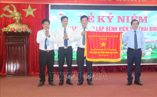 Trong ảnh: Phó Bí thư thường trực Tỉnh ủy, Chủ tịch HĐND tỉnh Thái Bình Nguyễn Tiến Thành (phải) trao tặng cờ thi đua của Chính phủ cho Bệnh viện Nhi Thái Bình. Ảnh: Thu Hoài - TTXVN