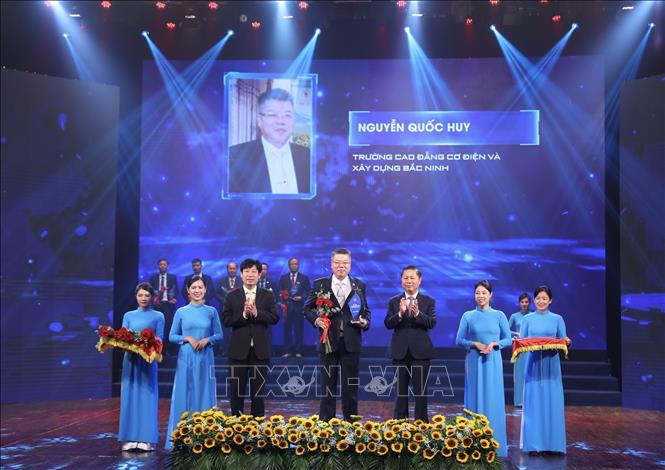 Thứ trưởng Bộ Lao động - Thương binh và Xã hội Lê Tấn Dũng trao biểu trưng vinh danh Nhà giáo tiêu biểu. Ảnh: Hoàng Hiếu - TTXVN 