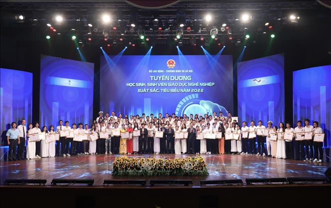 Thứ trưởng Bộ Lao động - Thương binh và Xã hội Lê Tấn Dũng, Phó Chủ tịch Tổng Liên đoàn Lao động Việt Nam Trần Văn Thuật với 100 học sinh, sinh viên tiêu biểu được tuyên dương. Ảnh: Hoàng Hiếu - TTXVN 