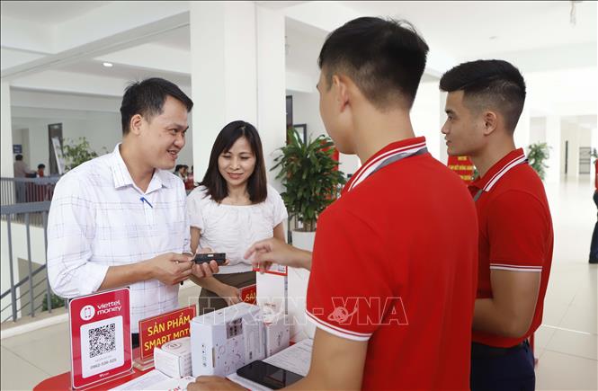 Trong ảnh: Khách hàng trải nghiệm sản phẩm chuyển đổi số tại Hội nghị. Ảnh: Hoàng Hùng – TTXVN