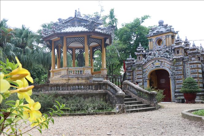 The main gate is made of lime bricks and has sophisticated carvings in porcelain and colored glass. Both sides depict elaborate images of dragons, phoenixes, unicorns, and flowers and engraved Chinese characters. VNA Photo: Đỗ Trưởng