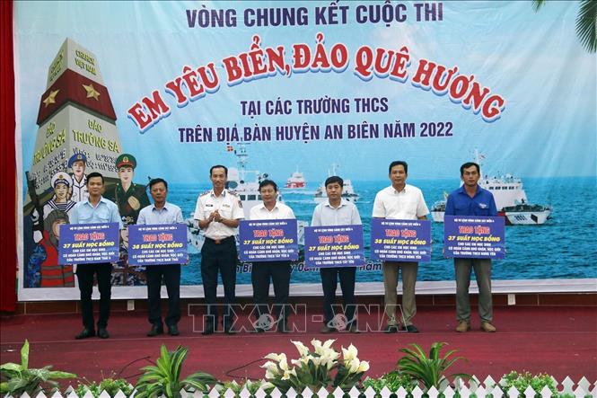 Đại tá Lê Văn Tú, Phó Chính ủy Bộ Tư lệnh Vùng Cảnh sát biển 4 trao bảng biểu trưng tặng học bổng cho học sinh nghèo trên địa bàn huyện. Ảnh: Lê Sen - TTXVN