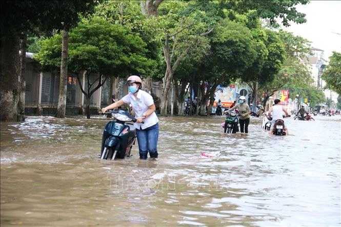 Trong ảnh: Nước dâng cao khiến việc đi lại của người dân gặp rất nhiều khó khắn. Ảnh: Lê Thúy Hằng - TTXVN