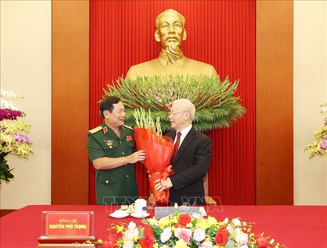 Thay mặt tuổi trẻ Quân đội, Thượng tướng Lê Huy Vịnh, Ủy viên Trung ương Đảng, Thứ trưởng Bộ Quốc phòng tặng hoa Tổng Bí thư Nguyễn Phú Trọng, Bí thư Quân ủy Trung ương.  Ảnh: Trí Dũng – TTXVN