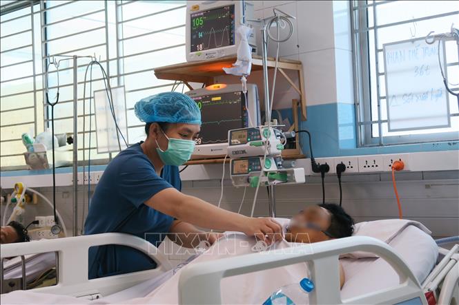 Trong ảnh: Nhân viên y tế của  Khoa Cấp cứu – Hồi sức tích cực – Chống độc người lớn, Bệnh viện Bệnh Nhiệt đới Thành phố Hồ Chí Minh chăm sóc cho bệnh nhân sốt xuất huyết nặng. Ảnh: Đinh Hằng - TTXVN
