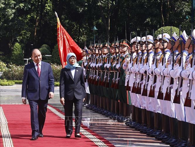 Chủ tịch nước Nguyễn Xuân Phúc và Tổng thống Cộng hòa Singapore Halimah Yacob duyệt Đội danh dự QĐND Việt Nam. Ảnh: Thống Nhất – TTXVN