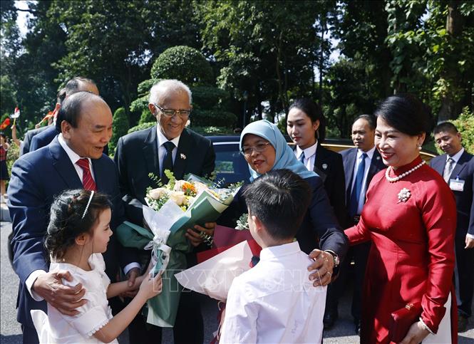 Chủ tịch nước Nguyễn Xuân Phúc và Phu nhân cùng Tổng thống Cộng hòa Singapore Halimah Yacob và Phu quân với thiếu nhi Thủ đô Hà Nội tại lễ đón. Ảnh: Thống Nhất – TTXVN