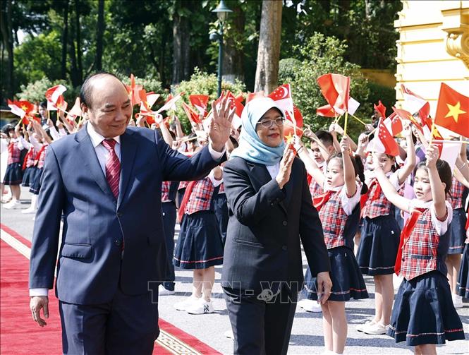 Chủ tịch nước Nguyễn Xuân Phúc và Tổng thống Cộng hòa Singapore Halimah Yacob với thiếu nhi Thủ đô Hà Nội tại lễ đón. Ảnh: Thống Nhất – TTXVN