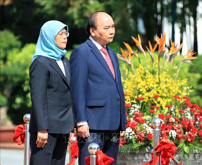 Chủ tịch nước Nguyễn Xuân Phúc và Tổng thống Cộng hòa Singapore Halimah Yacob nghe quân nhạc cử Quốc thiều hai nước. Ảnh: Thống Nhất – TTXVN