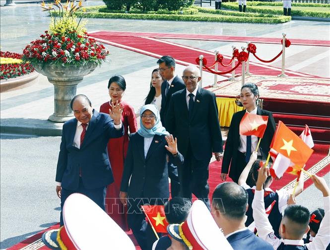 Chủ tịch nước Nguyễn Xuân Phúc và Phu nhân cùng Tổng thống Cộng hòa Singapore Halimah Yacob và Phu quân tại lễ đón. Ảnh: Thống Nhất – TTXVN