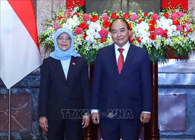 Chủ tịch nước Nguyễn Xuân Phúc và Tổng thống Cộng hòa Singapore Halimah Yacob chụp ảnh chung tại lễ đón. Ảnh: Thống Nhất-TTXVN