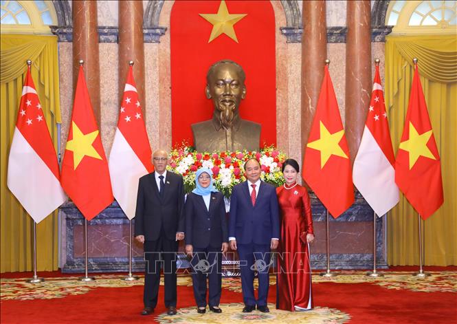 Chủ tịch nước Nguyễn Xuân Phúc và Phu nhân cùng Tổng thống Cộng hòa Singapore Halimah Yacob và Phu quân tại lễ đón. Ảnh: Văn Điệp - TTXVN