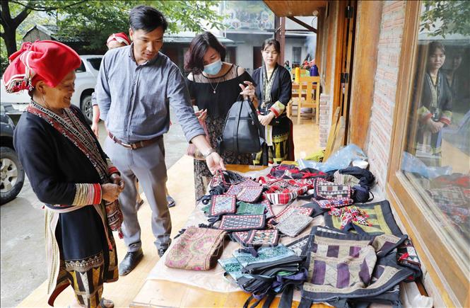Brocade products made by Red Dao ethnic women in Ta Phin commune, Sa Pa town are introduced to tourists. VNA Photo: Trần Việt 