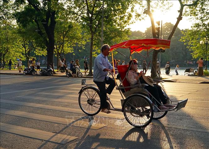 Tourists enjoy a cyclo ride in Hanoi. VNA Photo: Khánh Hòa 