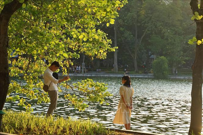 A couple enjoys their moment of autumn time at Hoan Kiem lake. VNA Photo: Khánh Hòa