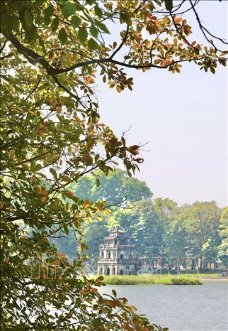 Hoan Kiem Lake with golden leaves and golden sun in autumn. VNA Photo: Hoàng Hiếu
