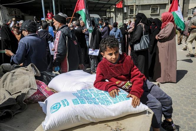 Người dân Palestine nhận lương thực cứu trợ tại một trung tâm phân phối của Cơ quan cứu trợ và hành động của LHQ (UNRWA) tại trại tị nạn Khan Yunis, Dải Gaza, ngày 7/3/2020. Ảnh: AFP/ TTXVN