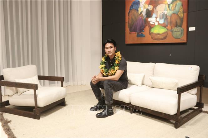 Trong ảnh: Nhà thiết kế tự do Vũ Đình Nghiêm bên tác phẩm Eastern Sofa. Ảnh: Xuân Anh -TTXVN