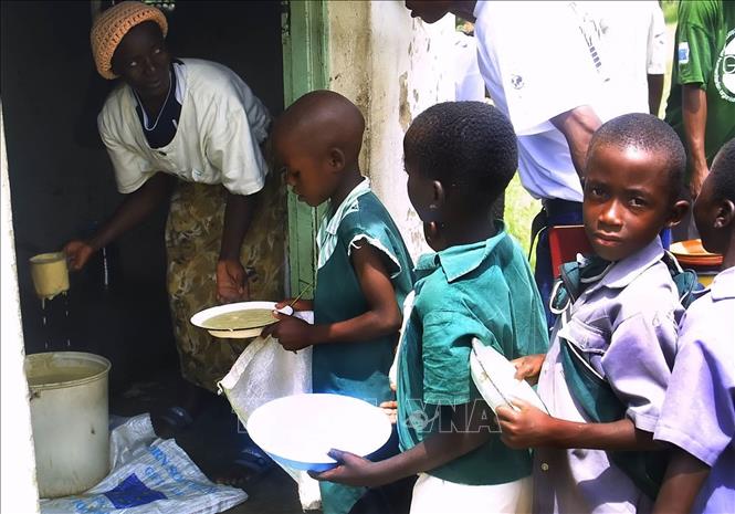 Trong ảnh: Trẻ em xếp hàng nhận bữa ăn do Chương trình Lương thực Thế giới tài trợ tại Harare, Zimbabwe. Ảnh: AFP/TTXVN