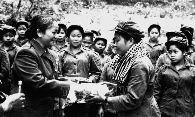 Chủ tịch Hội Liên hiệp Phụ nữ miền Nam Việt Nam Nguyễn Thị Định trao tặng phẩm cho đại đội nữ pháo binh trong chuyến thăm hữu nghị vùng giải phóng Lào (25 - 29/4/1974). Ảnh: Tư liệu TTXVN