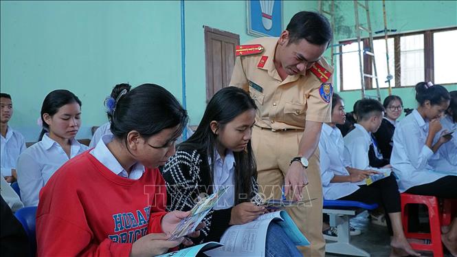 Cảnh sát giao thông tuyên truyền, phổ biến Luật Giao thông đường bộ cho học sinh. Ảnh: Hoài Nam – TTXVN