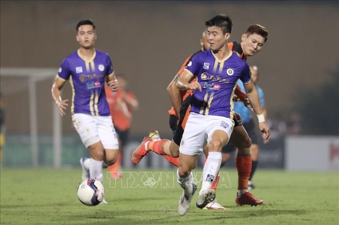 Pha tranh cướp bóng giữa hậu vệ Duy Mạnh (số 28, Hà Nội) và Phan Văn Long (số 11, Đà Nẵng). Ảnh: Minh Quyết - TTXVN