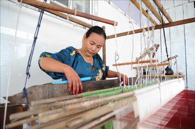 Neàng Chay Ty, a Khmer weaver at Srây Sakốth, Van Giao commune, concentrates on her loom. VNA Photo: Công Mạo