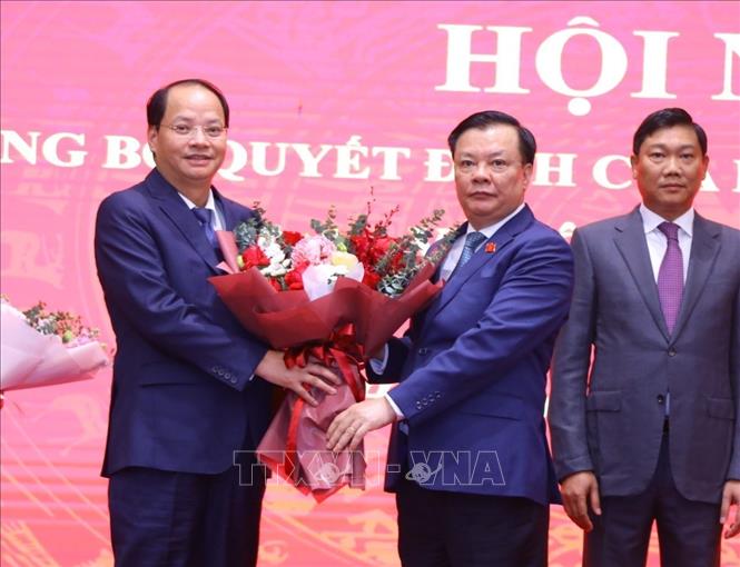 Bí thư Thành ủy Hà Nội Đinh Tiến Dũng trao quyết định, tặng hoa chúc mừng đồng chí Nguyễn Doãn Toản, tân Trưởng ban Tuyên giáo Thành ủy. Ảnh: Văn Điệp - TTXVN