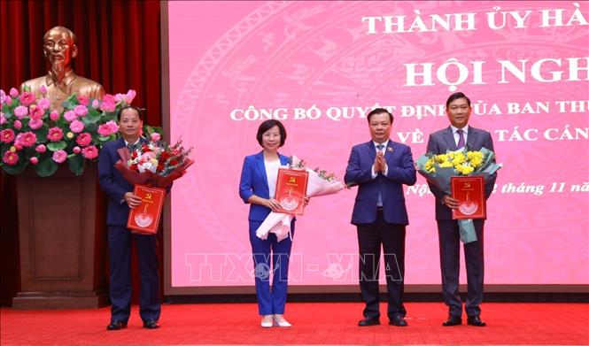 Bí thư Thành ủy Đinh Tiến Dũng trao quyết định, tặng hoa chúc mừng các đồng chí Bùi Huyền Mai, Nguyễn Doãn Toản (ngoài cùng, bên trái) và Đỗ Anh Tuấn. Ảnh: Văn Điệp - TTXVN