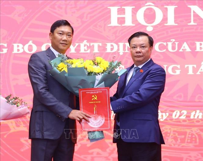 Bí thư Thành ủy Hà Nội Đinh Tiến Dũng trao quyết định, tặng hoa chúc mừng đồng chí Đỗ Anh Tuấn, tân Trưởng ban Dân vận Thành ủy. Ảnh: Văn Điệp - TTXVN