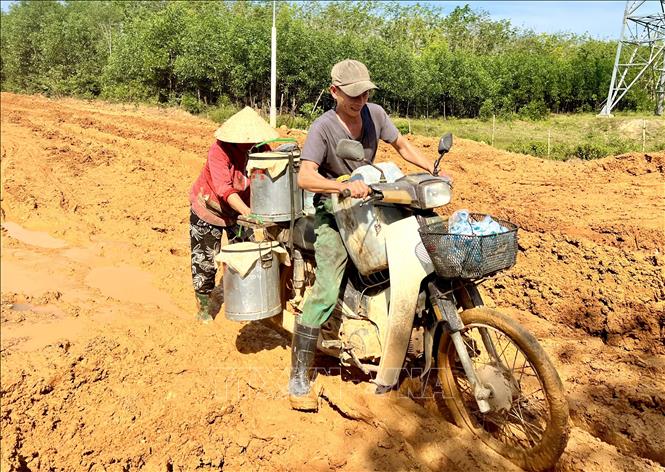 Người dân ở Trảng Rộng (xã Hải Thái, huyện Gio Linh) vất vả dùng xe máy tăng bo mủ cao su đi ra bên ngoài để bán cho thương lái. Ảnh: Nguyên Linh-TTXVN