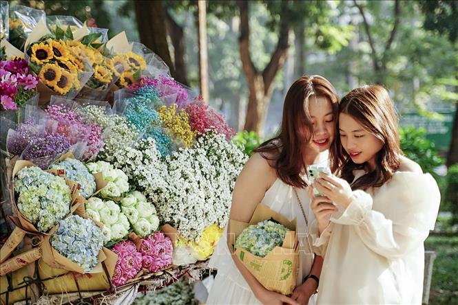 Các bạn trẻ chụp ảnh chung với xe hoa rực rỡ màu sắc . Ảnh: Khánh Hoà - TTXVN 