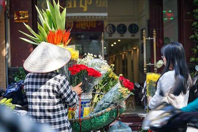 Mua hoa bán rong là một thói quen của người Hà Nội. Ảnh: Khánh Hoà - TTXVN