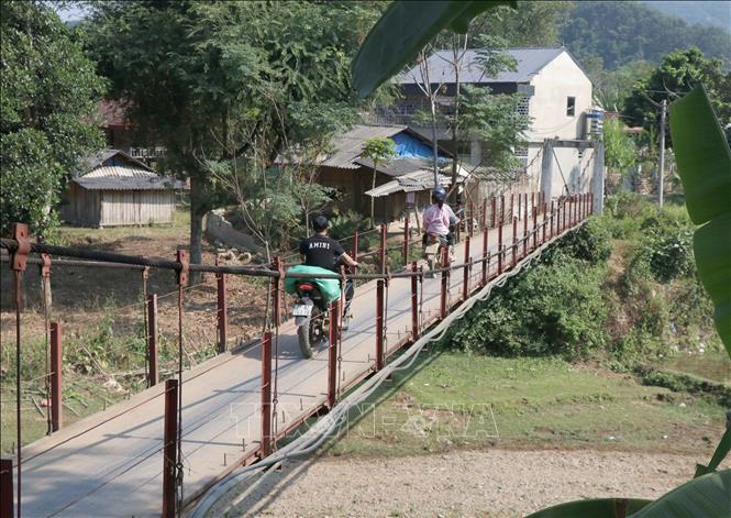 Trong ảnh: Cầu treo bắc qua suối Nậm Pun nối bản Lĩnh với quốc lộ 12 từ nhiều năm nay đã phá thế “ốc đảo”, giúp người dân trong  bản đi lại, thông thương trao đổi hàng hóa. Ảnh: Xuân Tiến – TTXVN 