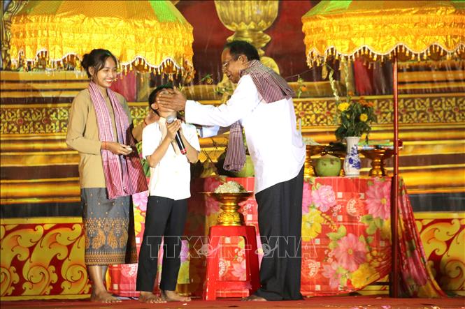 Nghi thức đút cốm dẹp cho trẻ em trong Lễ cúng trăng.  Ảnh: Thanh Hòa - TTXVN