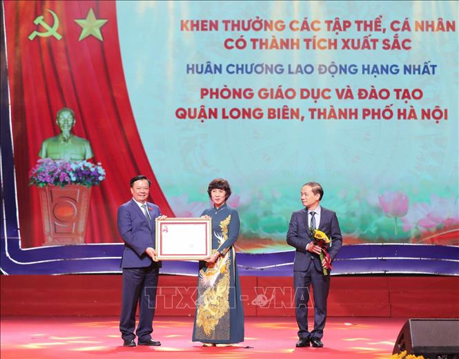 Bí thư Thành uỷ Hà Nội Đinh Tiến Dũng trao Huân chương Lao động hạng Nhất của Chủ tịch nước tặng Phòng Giáo dục và Đào tạo quận Long Biên. Ảnh: Thanh Tùng - TTXVN 